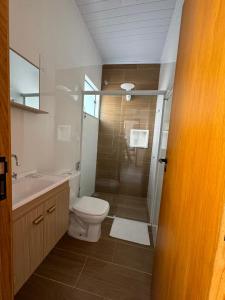 a bathroom with a shower and a toilet and a sink at Casa Sabor e Fé in Aparecida +47 photos