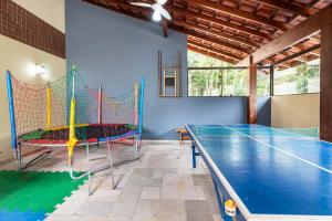 a ping pong table in a room with a ping pong net at Riviera Green - Premium Two in Riviera de São Lourenço