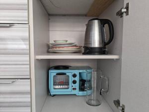 une cuisine avec un micro-ondes et une cafetière sur une étagère dans l'établissement Charming Studio Waikiki Hawaiian Monarch, à Honolulu
