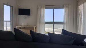 a living room with a couch and a large window at Rest Departamento con vista al mar in San Bernardo