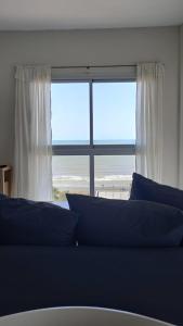 a bedroom with a window with a view of the beach at Rest Departamento con vista al mar in San Bernardo +31 photos