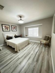 a bedroom with a large white bed and a chair at California Dreams in Lancaster