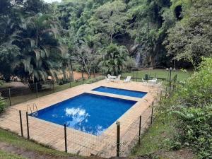 una piscina con acqua blu in un cortile di Condado de Pedra Itaipava Pedro do Rio a Barra Mansa