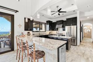 a kitchen with a large island with bar stools at Luxurious 3 Bedroom Villa in Coco