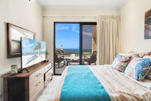a bedroom with a bed and a television and a balcony at Luxurious 3 Bedroom Villa in Coco