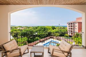 a balcony with chairs and a view of a pool at Ocean Views, Rooftop Terrace & Resort Pools in Tamarindo +20 photos