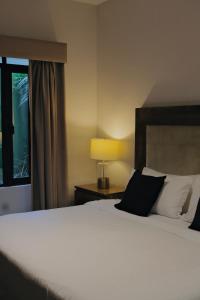 a bedroom with a white bed with a lamp and a window at Casa Mannach in Mexico City +43 photos