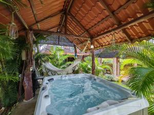 a jacuzzi tub in a garden with a hammock at Pitangus Lodge in Chachagua