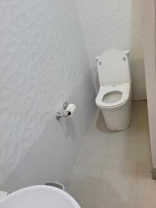 a bathroom with a toilet and a roll of toilet paper at Elpo's House in Panabo +14 photos