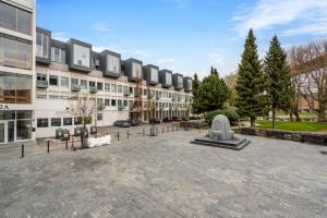 a large building with a statue in front of it at Large Room with Balcony -two storey condo- nearby Scandic Business Center bus stop in Stavanger