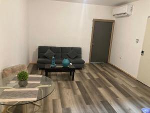 un soggiorno con un divano e un tavolo di Departamento amplio y tranquilo a Mexicali