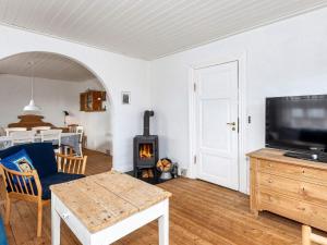 a living room with a fireplace and a tv at 6 person holiday home in Ålbæk-By Traum in Ålbæk