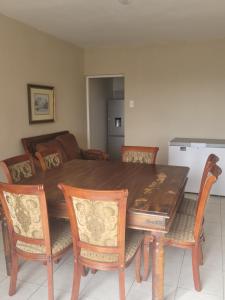 Una mesa de comedor con sillas y una cocina. en 44 on Lyme Road, en St Francis Bay