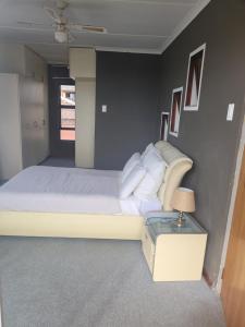 Un dormitorio con una cama grande y una mesa. en 44 on Lyme Road, en St Francis Bay