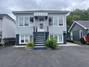 a white house with a porch and a driveway at Entire Apartment in Kingston