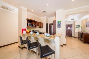a kitchen and living room with a counter and chairs at Ocean-View with 2 Infinity Pools & Veranda in Playa Flamingo +13 photos