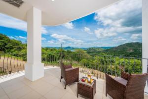 a balcony with two chairs and a table with a view at Ocean-View with 2 Infinity Pools & Veranda in Playa Flamingo