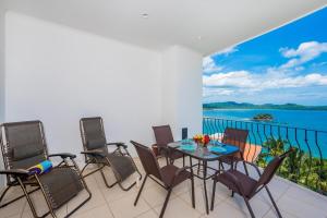 a balcony with a table and chairs and a view of the ocean at Ocean-View with 2 Infinity Pools & Veranda in Playa Flamingo