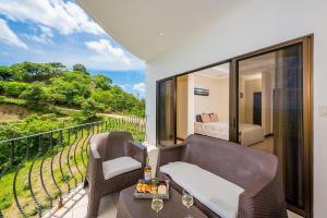 a room with a balcony with a bed and a table at Ocean-View with 2 Infinity Pools & Veranda in Playa Flamingo