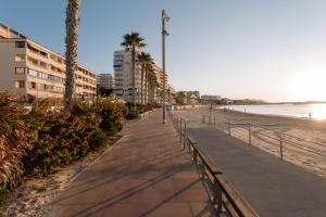 una acera junto a una playa con palmeras y edificios en Antic Rooms Varadero, en Villajoyosa
