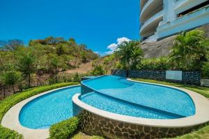 uma piscina em frente a um prédio em Spectacular Ocean View Condo em Playa Flamingo