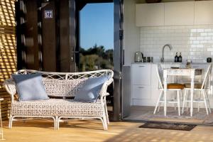 a wicker chair sitting in a kitchen with a table at One77 Rural Retreat in Matarawa