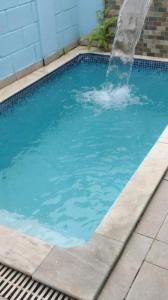 a swimming pool with a water fountain at casa itanhaém in Itanhaém