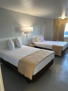 ein Hotelzimmer mit zwei Betten und einem Fenster in der Unterkunft Premier Inns Metro in Phoenix + 35 Fotos
