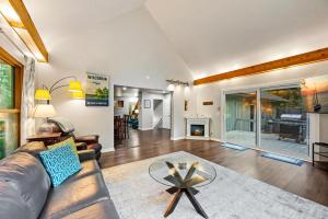un soggiorno con un divano e un tavolo di Scandia - Hot Tub, Arcade, Dog-Friendly, and Walk to Marina! a Sister Bay