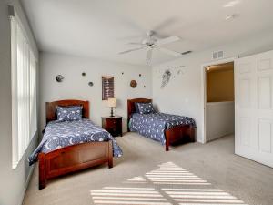 a bedroom with two beds and a ceiling fan at Charming & Cozy Getaway! Lazy River! in Davenport +23 photos