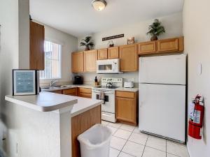 a kitchen with a white refrigerator and wooden cabinets at Charming & Cozy Getaway! Lazy River! in Davenport