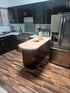 cocina con armarios negros y suelo de madera en La aldeadelicias, en Delicias 15 fotos más