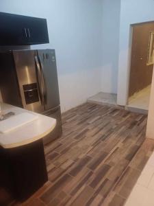 cocina con nevera de acero inoxidable y suelo de madera en La aldeadelicias, en Delicias