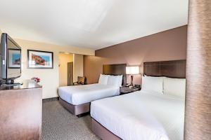 a hotel room with two beds and a sink at Grand Legacy At The Park in Anaheim