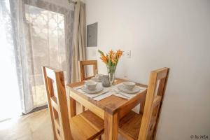 a dining room table with chairs and a vase of flowers at Roatan Infinity Pool and Ocean View Apartment in Jonesville