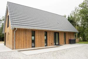a wooden house with a black roof at Mids in Midsland
