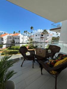 a patio with two chairs and a table on a balcony at Corals Retreat 2BR Beach Condo in Punta Cana