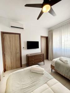 a bedroom with two beds and a ceiling fan at Corals Retreat 2BR Beach Condo in Punta Cana +18 photos