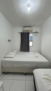 a bedroom with two beds and a window at Flats Duplex Super Aconchegantes e Confortáveis in Maragogi