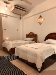 a bedroom with two beds and a ceiling at MRHostel Luxor in Luxor