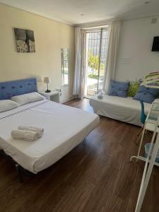 een slaapkamer met twee bedden en een raam bij El Parterre Apartamento in Valencia
