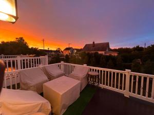 a balcony with a couch and a table and a sunset at Lux Townhome Free Parking 12 min to BWI in Brooklyn Park