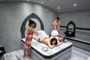 a group of people laying on a bed in a bath room at Hotel Samokov in Borovets