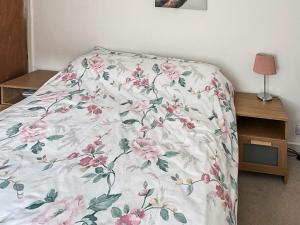 Bett mit Blumendecke in einem Schlafzimmer in der Unterkunft Kathali Cottage in Exmouth