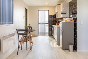 une cuisine avec une table et un réfrigérateur dans l'établissement Wigram Escape Minutes to Ngā Puna Wai Sports Hub, à Christchurch 10 autres photos