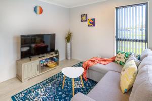 un salon avec un canapé et une télévision dans l'établissement Wigram Escape Minutes to Ngā Puna Wai Sports Hub, à Christchurch
