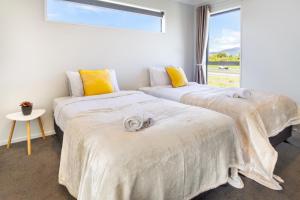 deux lits dans une chambre avec une fenêtre dans l'établissement Wigram Escape Minutes to Ngā Puna Wai Sports Hub, à Christchurch