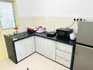 a kitchen with a counter with a sink and a microwave at Spc Arena Apartment Service in Bayan Lepas