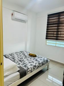 a white room with a bed with a black and white mattress at Spc Arena Apartment Service in Bayan Lepas +4 photos