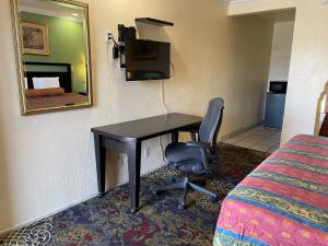 a desk in a hotel room with a bed and a chair at Cloud 9 in Cypress